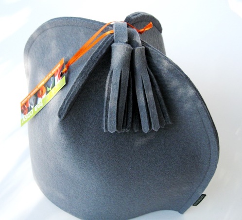 Grey wool felt modern tea cosy with two tassels emerging from its top.