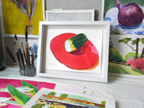 Small watercolour painting of cucumber on a bright red plate