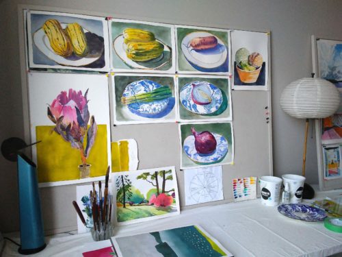 Worktable view of small watercolour still life paintings
