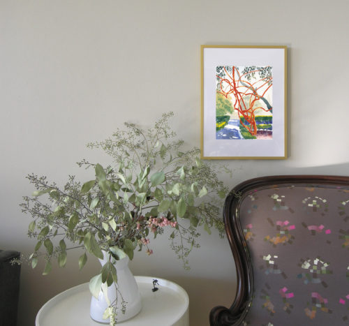 In situ photo of watercolour painting of red bush above an armchair