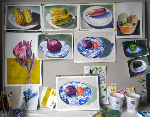 A group of watercolour paintings depicting fruit and vegetables on blue china plates