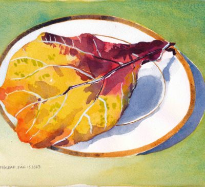 Small original watercolour painting of a large fiddle leaf fig leaf that has faded to bright yellow, orange and red sitting on a white gold-rimmed china plate
